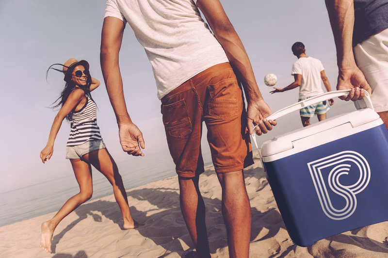Young pals carrying a cooler on the beach